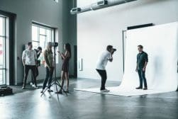 A group of people taking pictures in a studio.