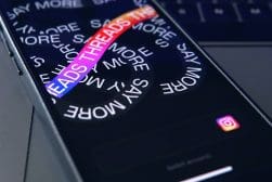 A cell phone with the word THREADS displayed on it.