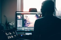 A man sitting in front of a computer screen.