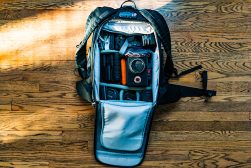 A backpack is sitting on a wooden floor.