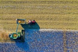 An aerial view of a combine harvester in a field.