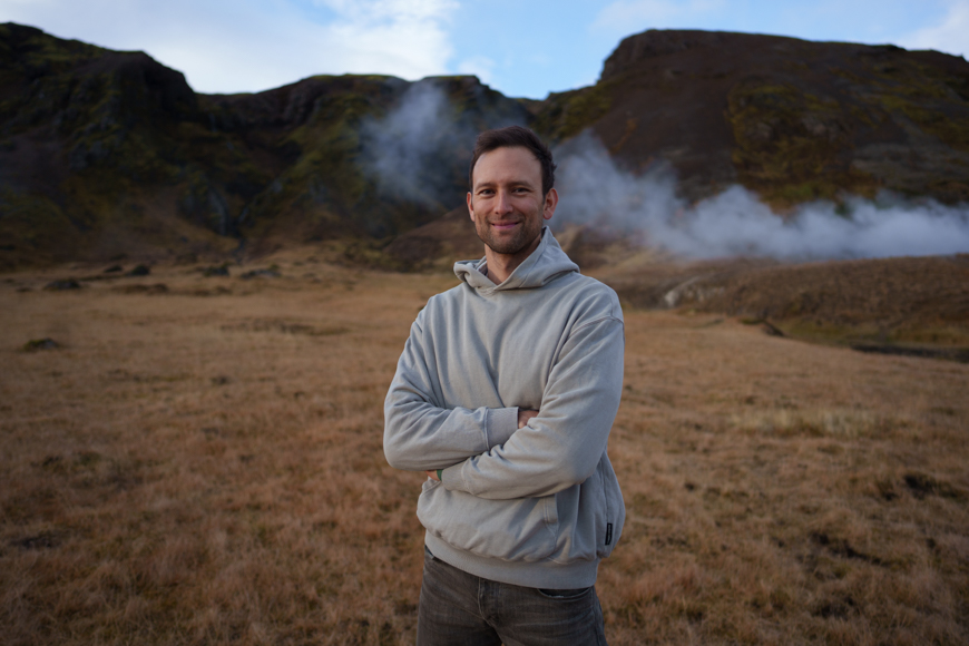 A man standing in front of a field with steam coming out of it. A man standing in front of a field with steam coming out of it.