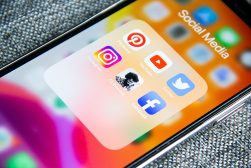 A cell phone with social media icons on it.