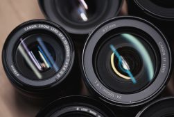 A group of camera lenses on a wooden surface.