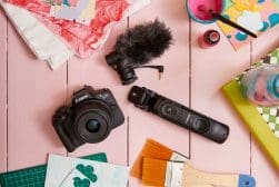 A camera and other objects on a pink table.