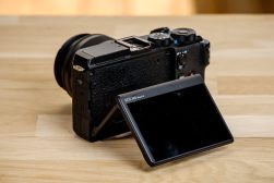 A camera is sitting on a wooden table.