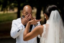 A bride and groom kissing in front of a tree.
