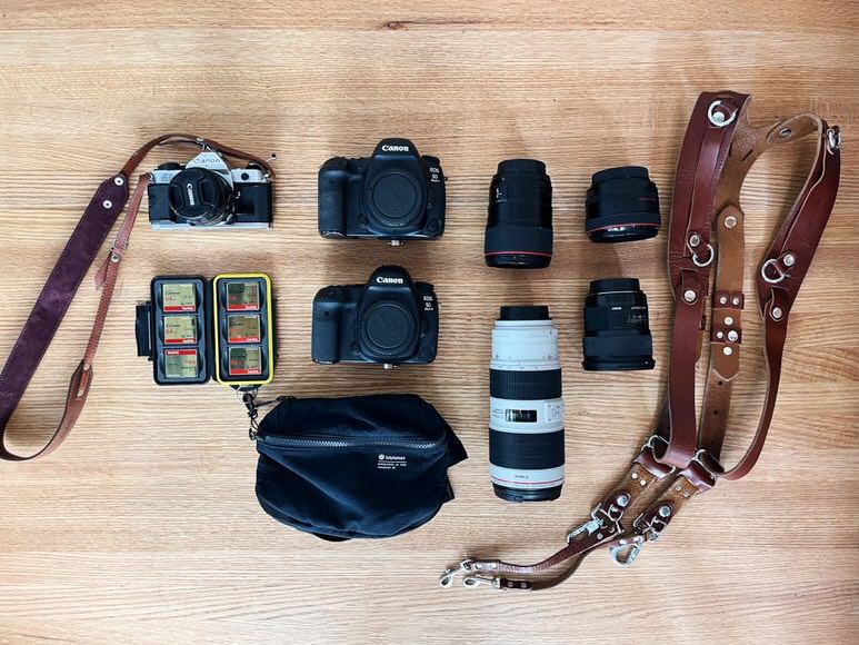 A collection of camera equipment on a wooden table.