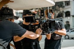 A group of people working with a camera on a street.