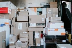 Many boxes are piled up in the back of a truck.