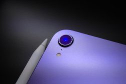 A close up of a purple iPad on a black surface.