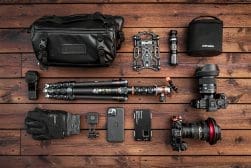 A camera bag with a camera, tripod, and other items.