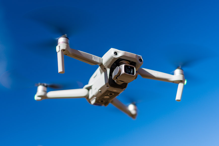 A drone flying in the sky with propellers.