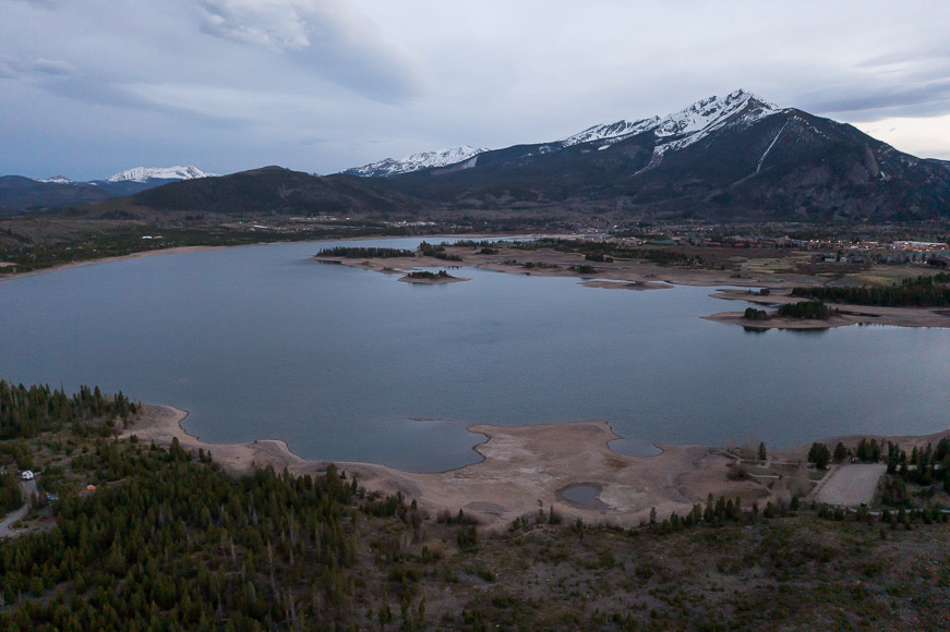 An aerial view of a lake with mountains in the background.