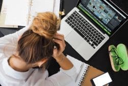 A woman is sitting at a desk with a laptop.