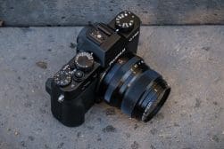 A black camera with a lens laying on the ground.
