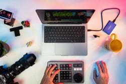 A desk with a laptop, camera, and other equipment.
