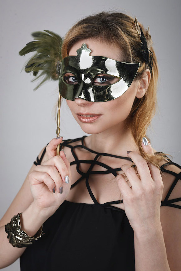 A woman wearing a mask and holding a stick.