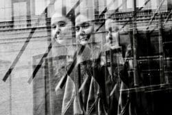 A black and white photo of a group of people looking out of a window.