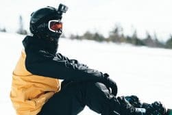A person sitting on a snowboard in the snow.