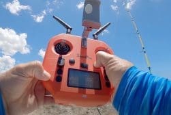A person holding a remote control device in the air.