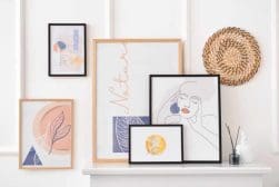Four framed prints on a white mantle.