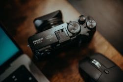 A camera sitting next to a laptop and mouse.