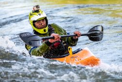 a man riding a kayak on top of a body of water with a go pro camera attached