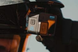 A person wearing a helmet is holding a gopro camera.