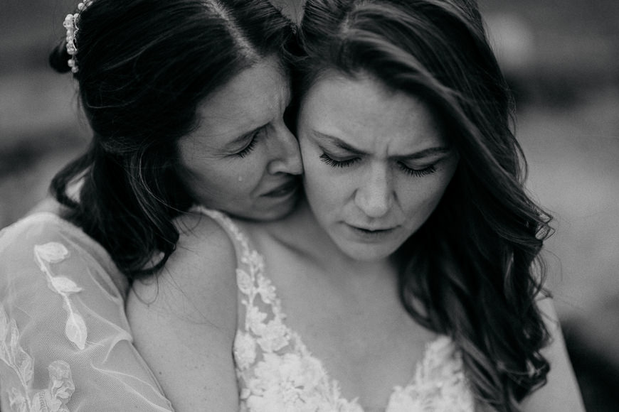 Two women hugging each other in black and white.