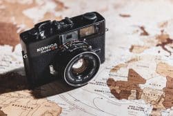 A camera sits on top of a world map.