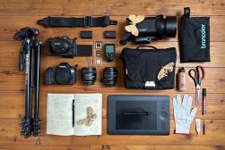 a collection of camera equipment laid out on a wooden floor.