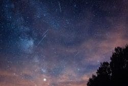 A night sky with shooting stars and a milky way.