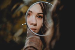 a woman looking into a magnifying glass.