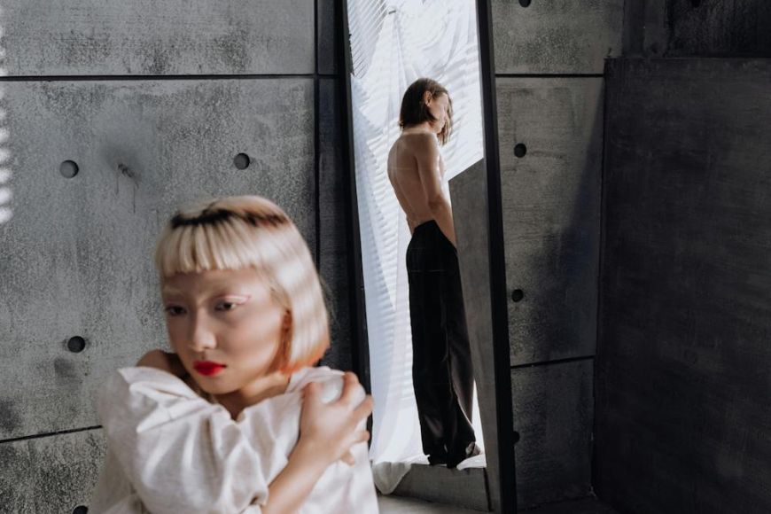 A woman is standing in front of a mirror.