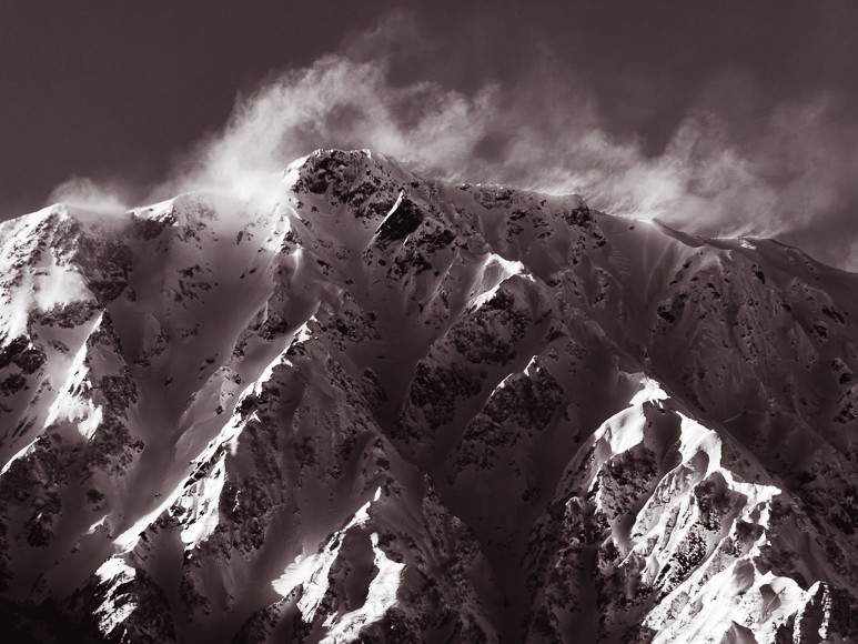 A snowy mountain with clouds.