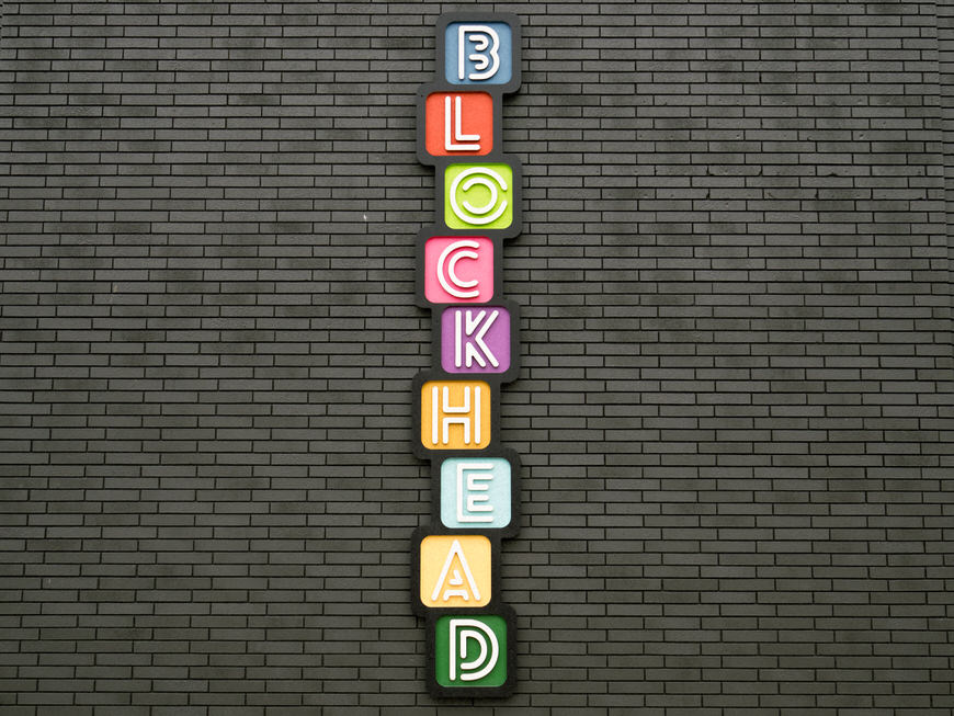 A brick wall with a sign that says blockhead.