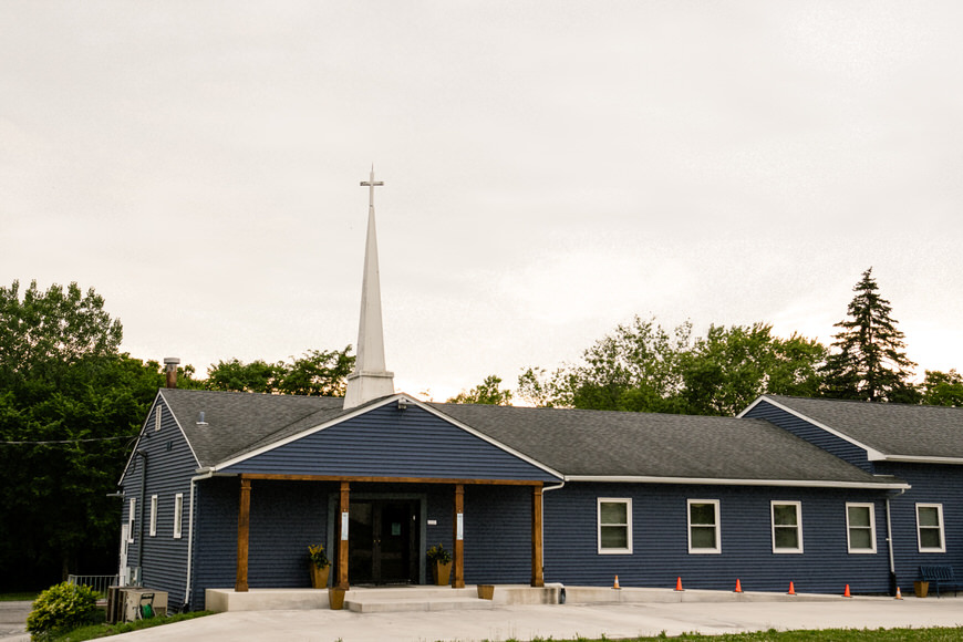 A blue church building with a steeple.