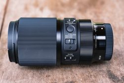 A black lens sitting on top of a wooden table.