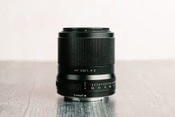 A black lens sitting on top of a wooden table.