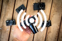 A person holding a hand up to a group of wi-fi enabled cameras.