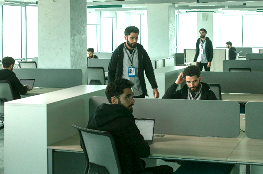A group of people sitting at desks in an office.