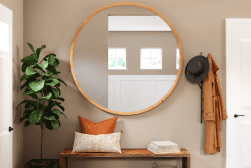 A hallway with a bench and a mirror.