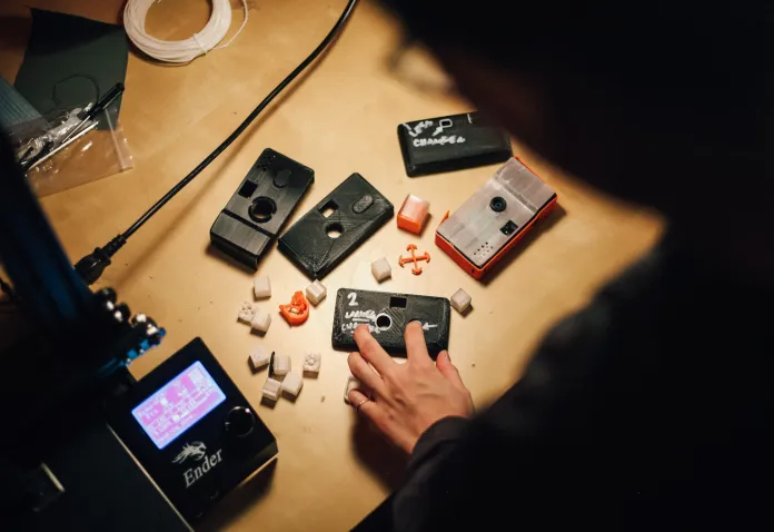 A person's hand on a table with objects on it.